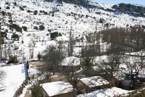 a snow covered hillside with trees and buildings at Casas Rurales Los Enebros Nerpio in Nerpio