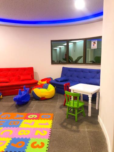 a room with a couch and a table and chairs at Arraial Praia Ap - Residence Club Praia dos Anjos in Arraial do Cabo