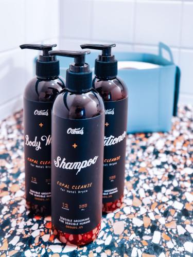 three bottles of shampoo sitting on a counter at Hotel Dryce in Fort Worth