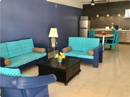 a living room with two blue chairs and a table at My Beach Condo RG5 in Puerto Vallarta