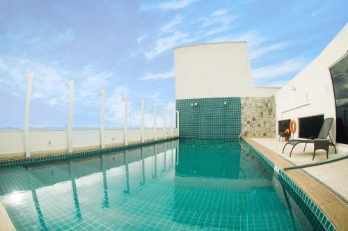 uma piscina com duas cadeiras ao lado de um edifício em Diff Hotel em Rio Branco