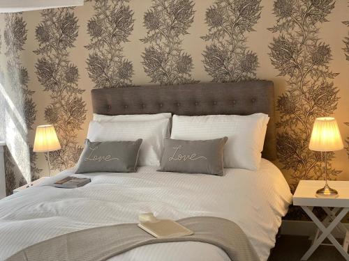um quarto com uma cama grande e almofadas brancas em Lovely Entire Flat in Birnam, neighbouring Dunkeld em Birnam