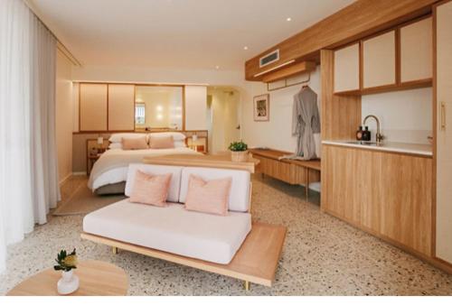 a large bedroom with a bed and a kitchen at The Surf Yamba in Yamba