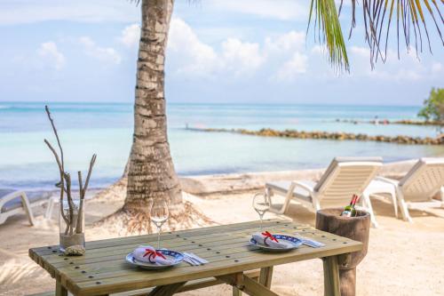 a wooden table on the beach with a palm tree at Tintipan Cabana SalSiPuedes in Tintipan Island