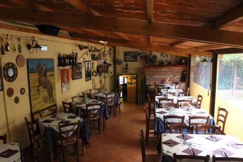 a restaurant with tables and chairs in a room at Albergo La Portaccia in Castiglione della Pescaia