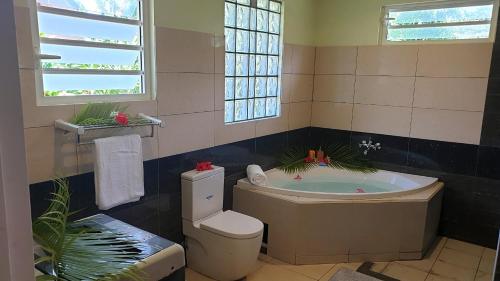 a bathroom with a tub and a toilet at MOOREA - Villa Maoe Pool in Afareaitu