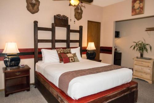 a bedroom with a large bed and two lamps at Lokahi Lodge in Volcano