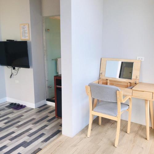 a room with a desk and a chair and a mirror at One Way B&B in Hualien City