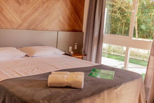 a bedroom with a bed with two towels on it at Morada do Estaleiro in Balneário Camboriú