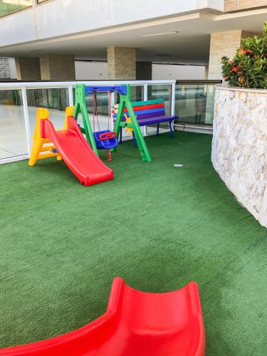 a playground with colorful play equipment on a building at Arraial Praia Ap - Residence Club Praia dos Anjos in Arraial do Cabo