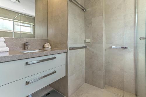 W łazience znajduje się prysznic i umywalka. w obiekcie Serenity on Hastings Street, Noosa Heads w mieście Noosa Heads
