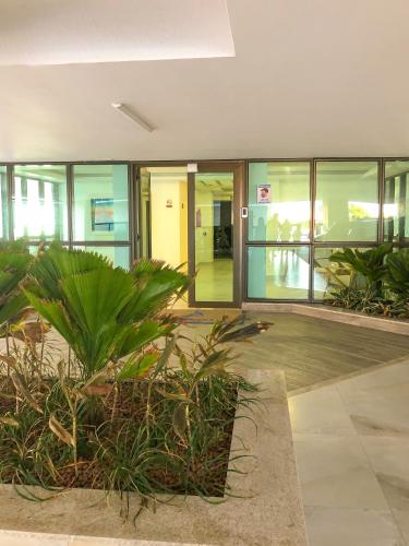 a large building with glass doors and plants in it at Arraial Praia Ap - Residence Club Praia dos Anjos in Arraial do Cabo