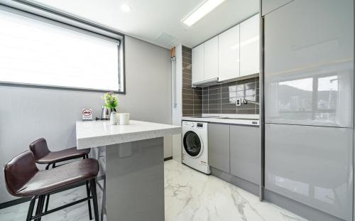 a kitchen with a washer and dryer on a counter at Songjeong Blue Castle Hotel in Busan