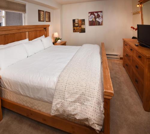 um quarto com uma cama grande e uma televisão em Vantage Point 101 Condo em Vail