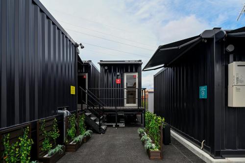 a row of black shipping containers with plants at HOTEL R9 The Yard Tsuyama in Tuyama