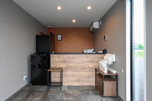 a kitchen with a counter and a refrigerator at HOTEL R9 The Yard Tsuyama in Tuyama