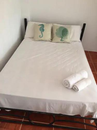 a bed with two towels and two pillows on it at La Casa de Mike in Puerto Villamil