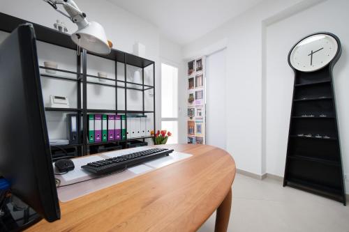 a desk with a computer keyboard and a clock at Finestre d'Occidente in Trapani