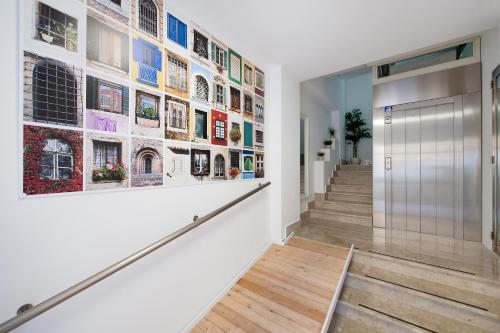 a hallway with stairs and a large wall of pictures at Finestre d'Occidente in Trapani