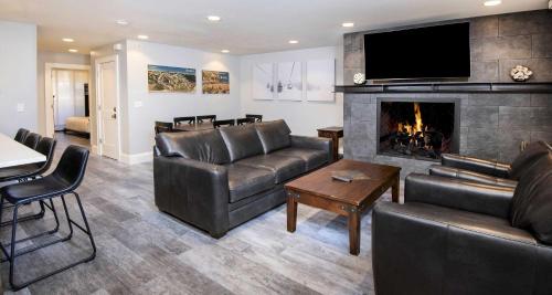 a living room with leather furniture and a fireplace at Scorpio #104 Condo in Vail