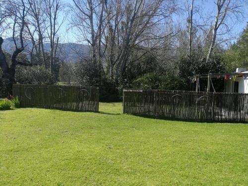 a wooden fence in a yard with a grass field at Klipfontein Rustic Farm & Camping in Tulbagh