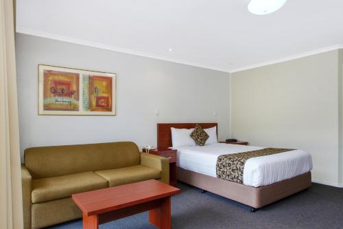 a hotel room with a bed and a couch at Thunderbird Motel Yass in Yass