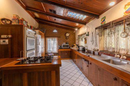 uma cozinha com armários de madeira e um forno com placa de fogão em Lemke Cottage Barossa Valley 