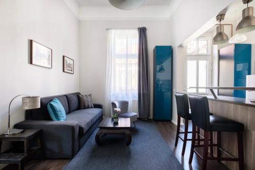 - un salon avec un canapé et un bar dans l'établissement Andrassy Garden Apartment in Center, à Budapest