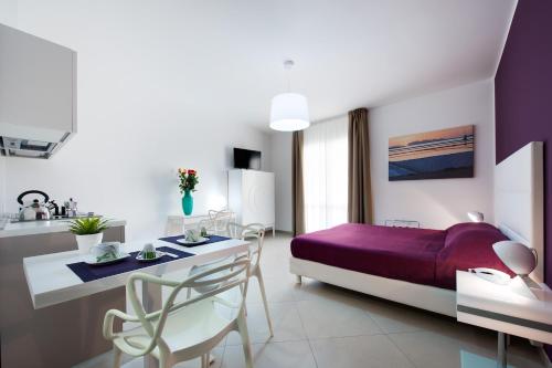 a bedroom with a purple bed and a table and chairs at Finestre d'Occidente in Trapani