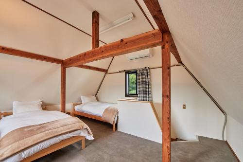 an attic bedroom with a bed and a window at Sunnsnow Tall house in Nagano