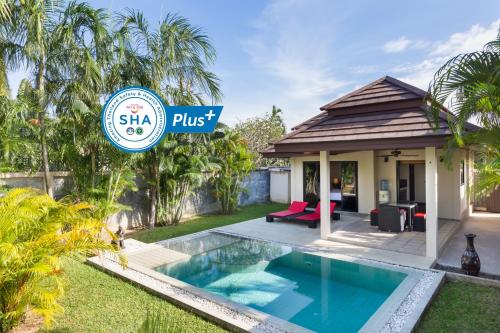a villa with a swimming pool in front of a house at Phuket Pool Residence - SHA Extra Plus in Rawai Beach