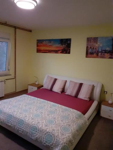 a bedroom with a bed and two paintings on the wall at Maja in Velika Gorica