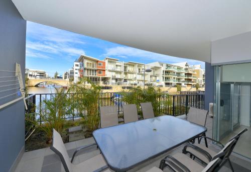 a table and chairs on a balcony with a view of condos at DelMar 3 in Mandurah