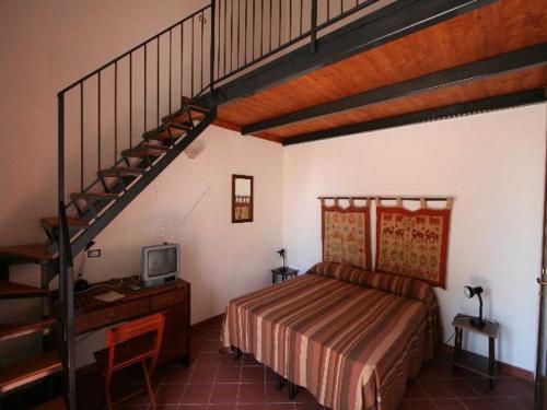 a bedroom with a bed and a staircase with a bed and a desk at Baglio Delle Rose in Giarre