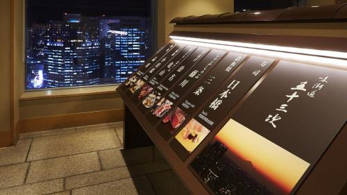 a bench in a room with a view of a city at Shinagawa Prince Hotel in Tokyo