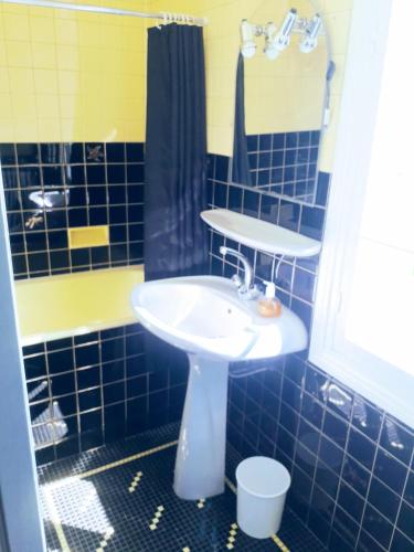 une salle de bain carrelée bleue avec un lavabo et une douche dans l'établissement L'ermitage, à Agen