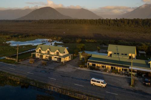 an aerial view of a building with mountains in the background at Haast Beach Motel in Haast