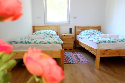 1 dormitorio con 2 camas y ventana en Friends & Family Apartmanok Velence, en Velence