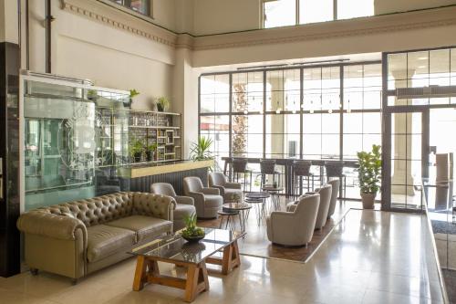 a living room with a couch and chairs and tables at New Balturk Hotel Izmit in Kocaeli