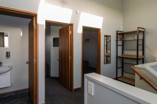 a bathroom with two doors and a sink at Haast Beach Motel in Haast