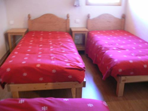 dwa łóżka z czerwonymi kołdrami w pokoju w obiekcie Appartement Valloire, 5 pièces, 10 personnes - FR-1-263-187 w mieście Valloire