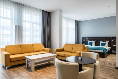 a living room with a couch and a bed at RheinCity Hotel & Boardinghouse in Ludwigshafen am Rhein