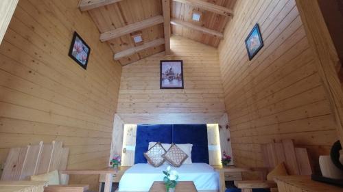 a bedroom in a log cabin with a bed at Rooftop Cottages & Restaurant, Pangot in Nainital