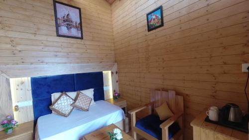 a bedroom with a bed in a wooden room at Rooftop Cottages & Restaurant, Pangot in Nainital