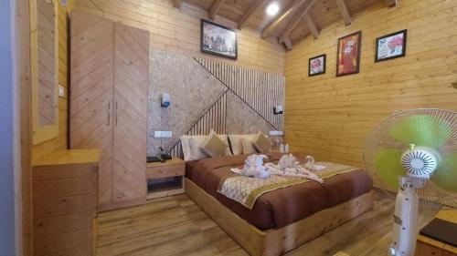 a bedroom with a bed with two dolls on it at Rooftop Cottages & Restaurant, Pangot in Nainital