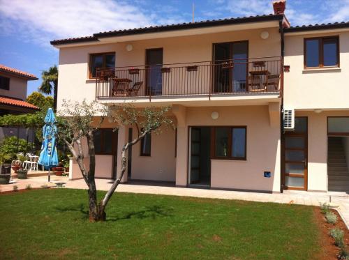 vistas a una casa con un árbol en el patio en Solaria Apartments Porec, en Poreč