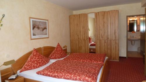 a bedroom with a red bed with red pillows at Ferienhaus am Sonnenhang in Willingen