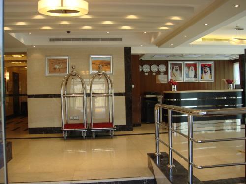 a lobby with two clocks on the wall at Paragon Hotel Apartments in Abu Dhabi