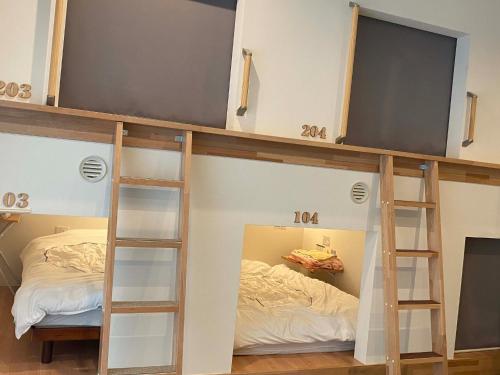 弘前市にあるHOSTEL HIROSAKI -Mixed dormitory-Vacation STAY 32012vの二段ベッド2台とベッド1台が備わる客室です。