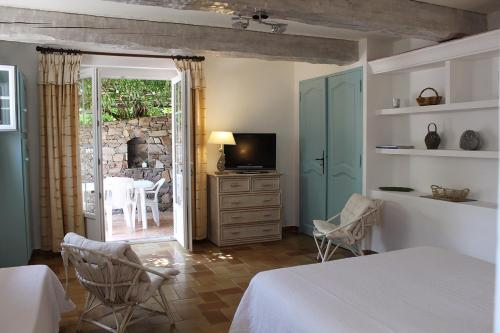 Schlafzimmer mit einem Bett, einem TV und einer Terrasse in der Unterkunft Saint Joseph in Grimaud